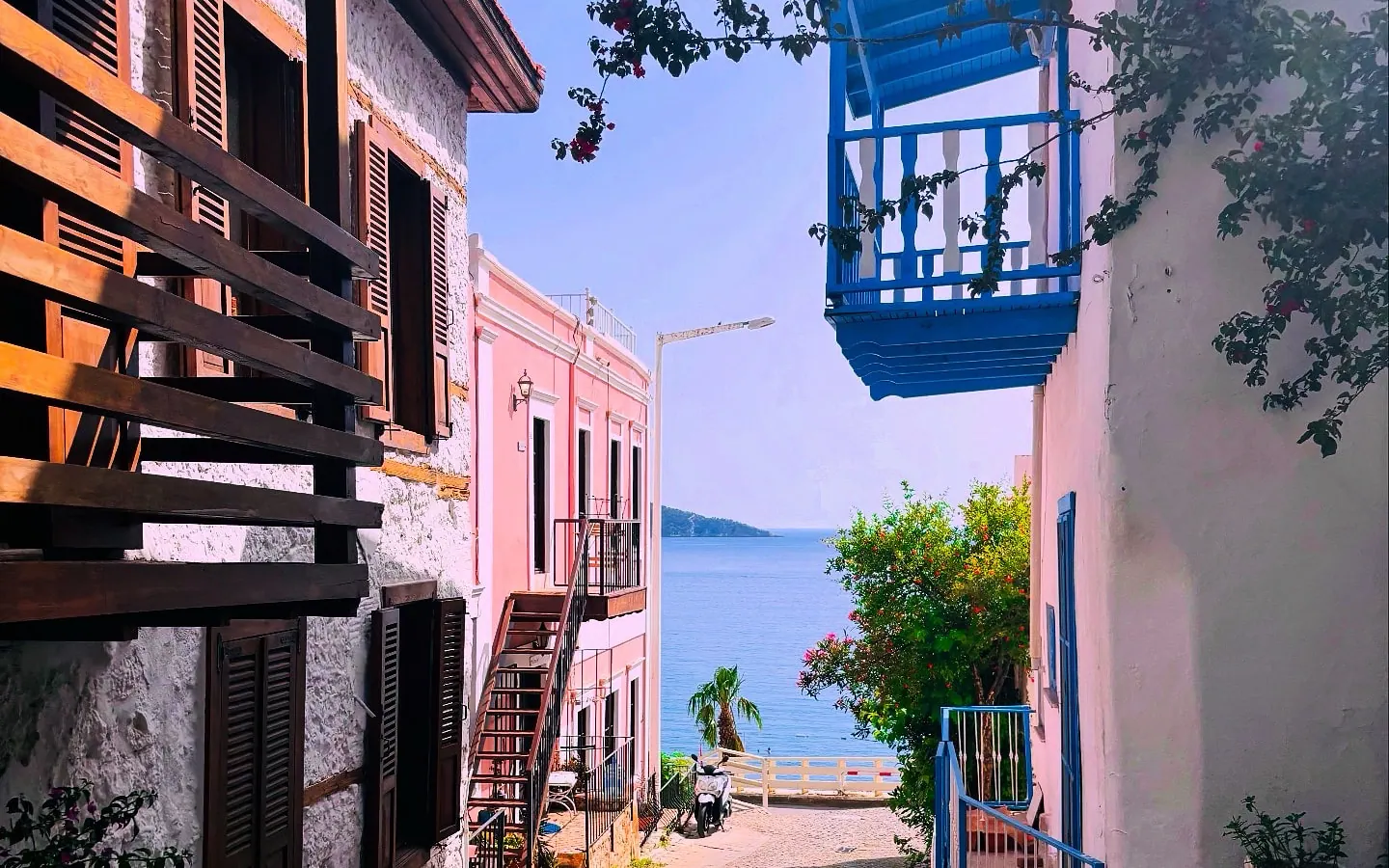Kalkan eski şehirde denize inen taş sokak ve mavi balkonlu evler