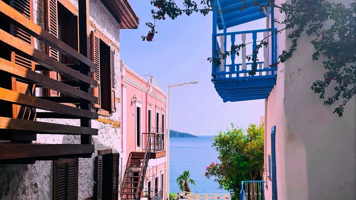 Kalkan eski şehirde denize inen taş sokak ve mavi balkonlu evler